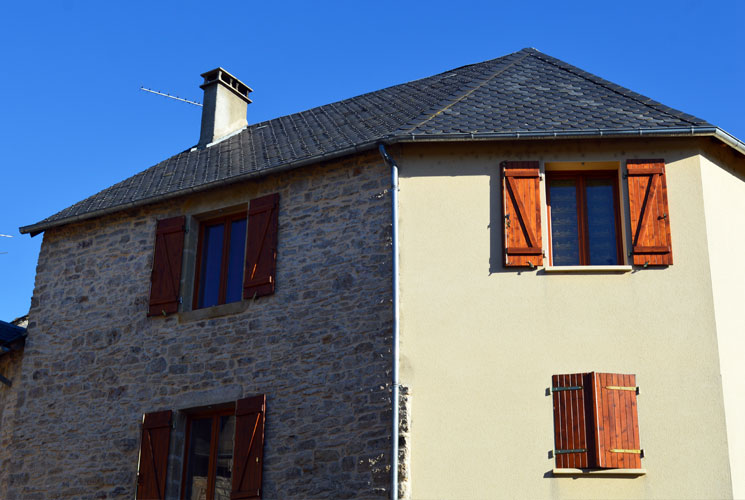 Façade détériorée d'une maison résidentielle avant travaux de ravalement.